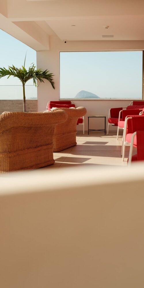 Red chairs with whicker lounge chairs on a hotel terrace
