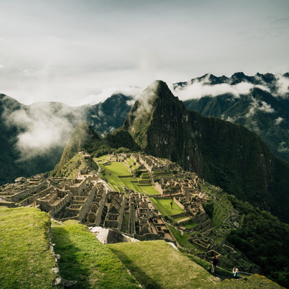 Lush green grass and the different levels of Machu Picchu on a cloudy day