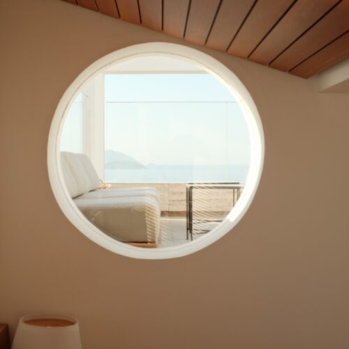 A circular window showing a hotel patio in the distance