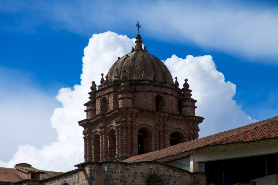 Qorikancha in front of a blue sky with a big cloud